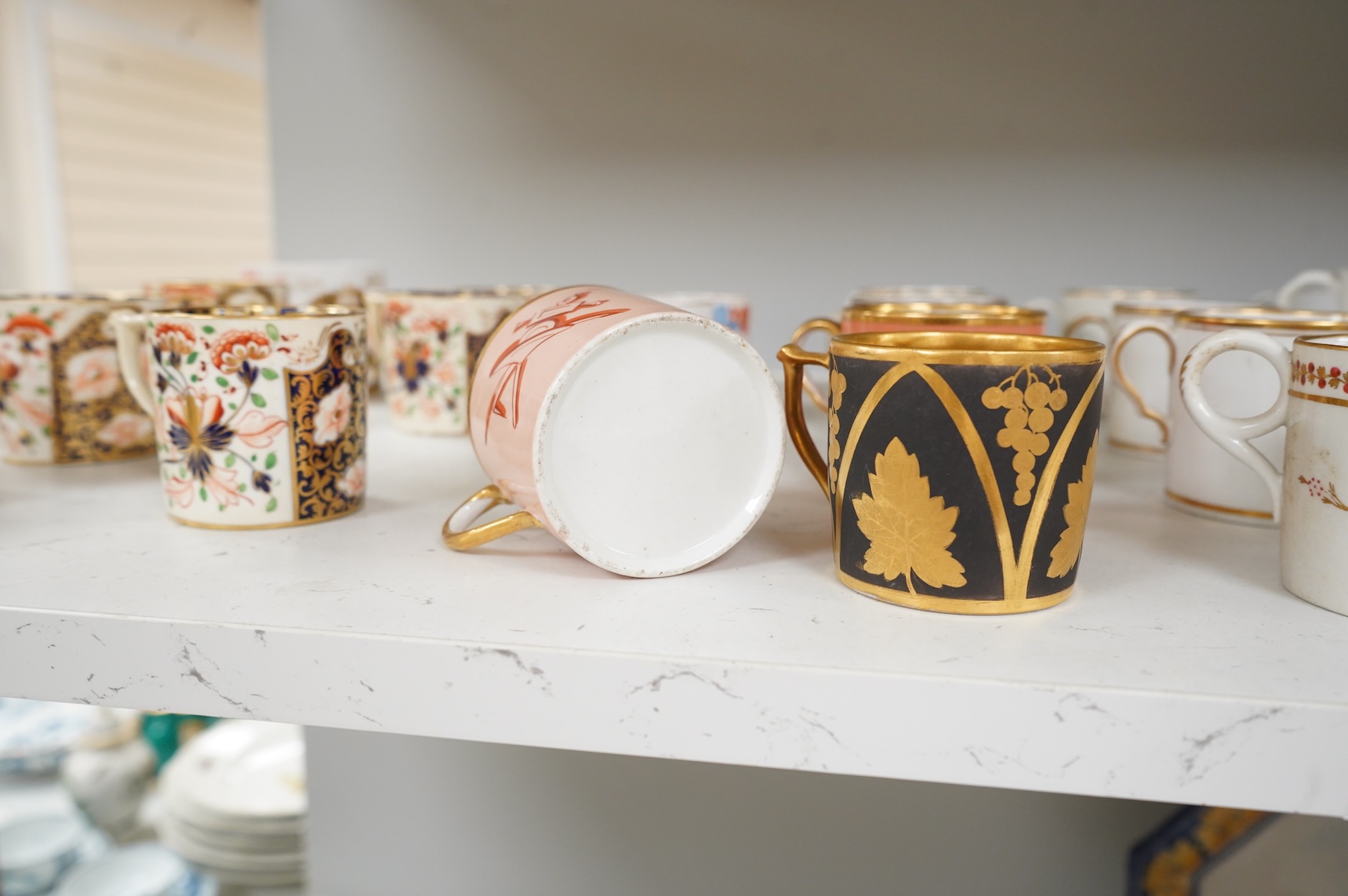 A collection of late 18th/19th century English and French porcelain coffee cans, tea cups and vases, some in Imari pattern